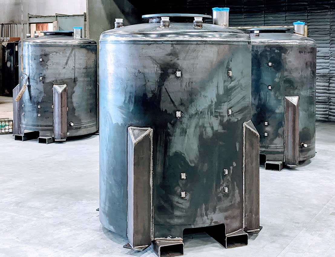 carbon steel holding tanks or hoppers showing welds and skids