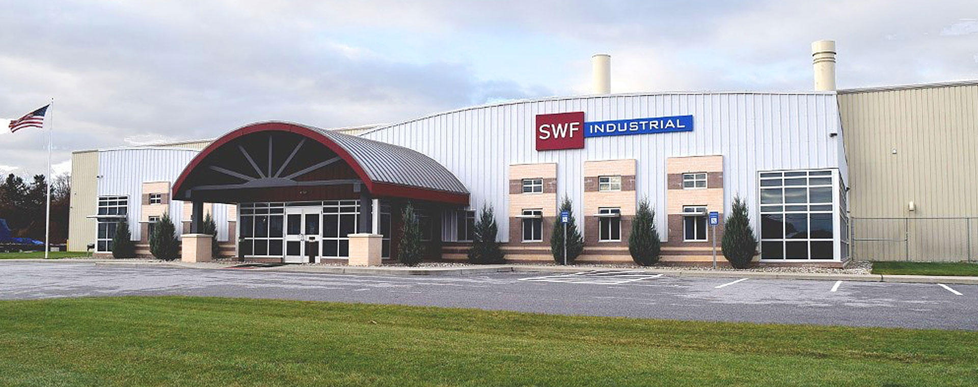 SWF Industrial building shown from front facing shot, with red canopy and large warehouse shown behind office
