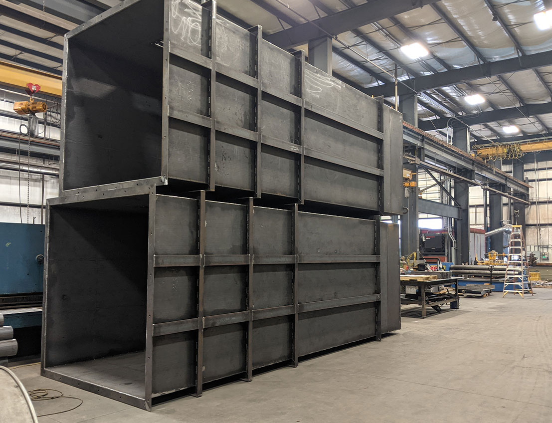 Dark steel gay heavy industrial reinforced oxide bins stacked on the factory floor
