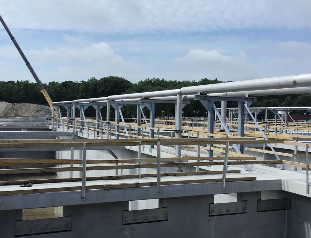 Water wastewater complex process piping seen over containment pondStainless Piping