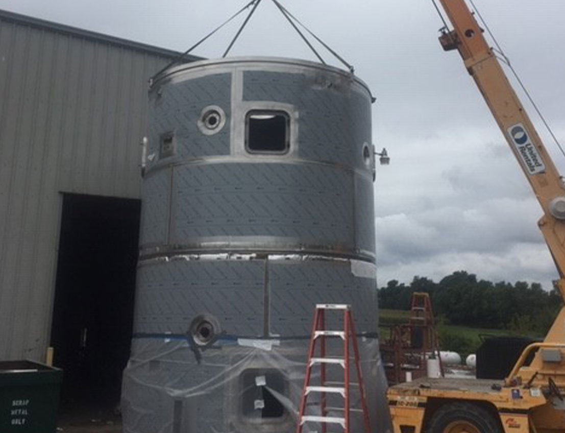 stainless steel spray dryer being installed with a large crane on it's right