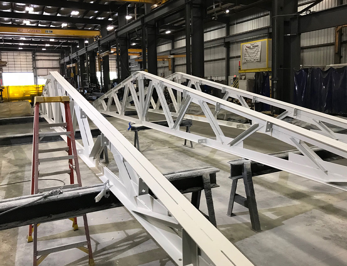 Structural steel truss: Painted carbon steel roof truss with custom options, built to fit, with faster lead times than ordering and waiting for off the shelf, catalog solutions.
