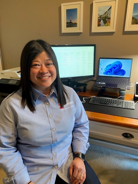 Mary Phong, in the business development office, smiling at the camera in a blue button-down SWF shirt.