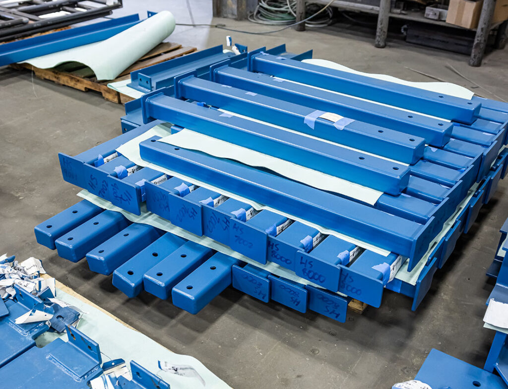 platform parts made of blue painted carbon steel stacked on a pallet