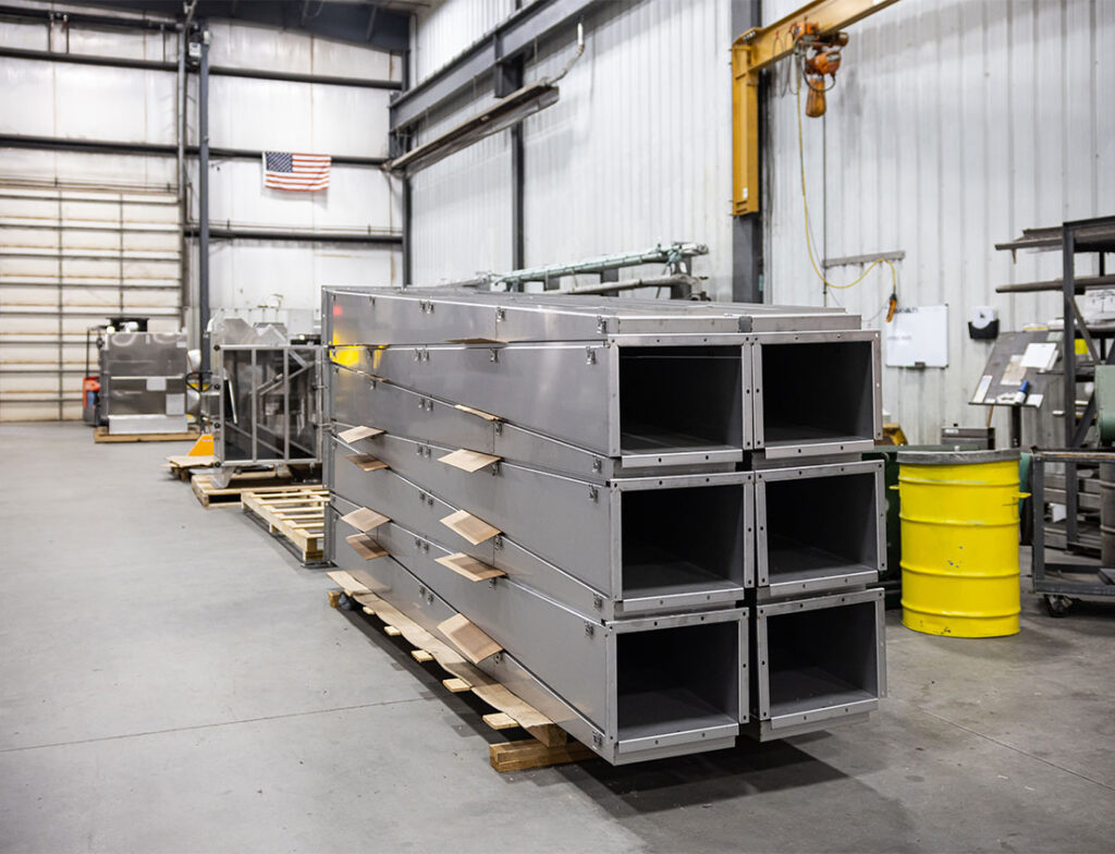 Stainless steel air distribution plenums stacked on a pallet