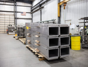 Stainless steel air distribution plenums stacked on a pallet