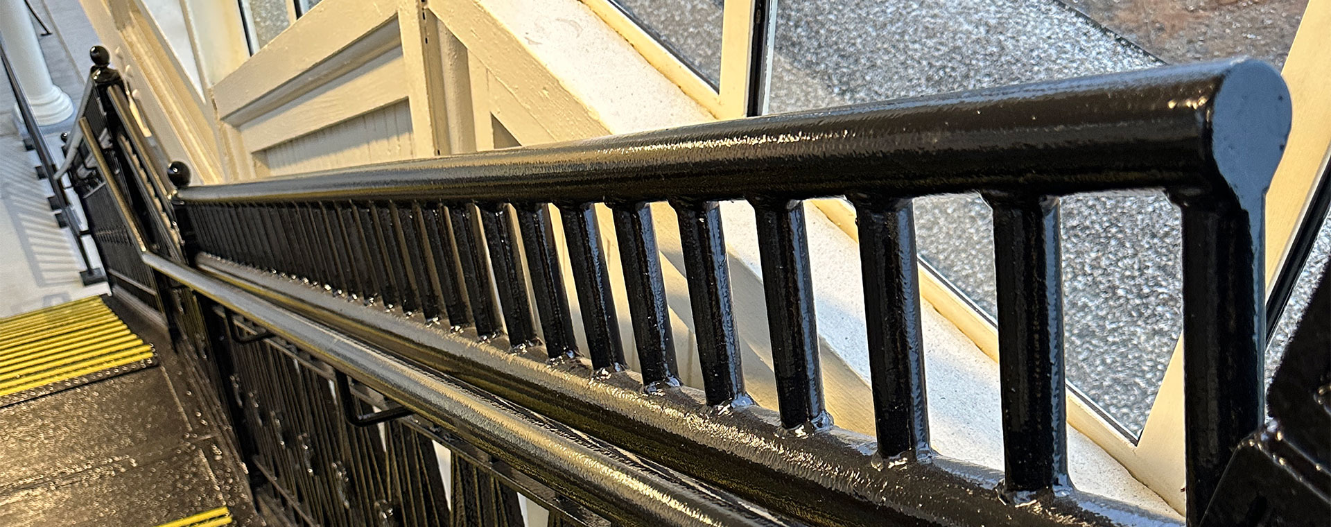 Detail image of the grab bar extensions to the handrails on the historic AMTRACK station stairway.
