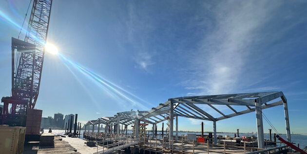 A panoramic view of the skyline, a crane, and the canopy under construction.